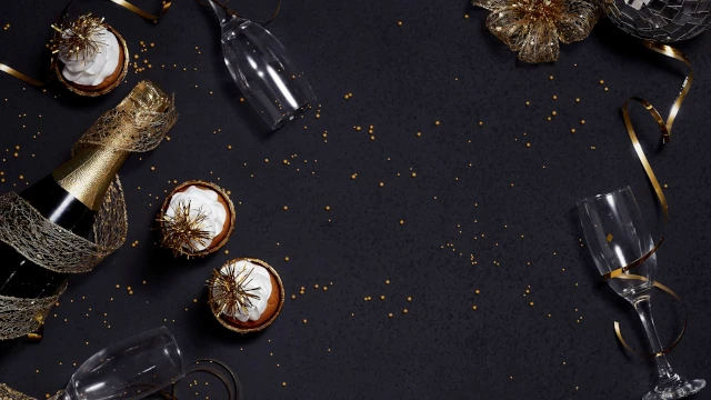 A stock image showing a champagne bottle, glasses and decoration.