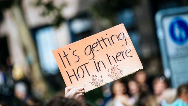 A photo of a hand-made sign with the text It's Getting Hot in Here.